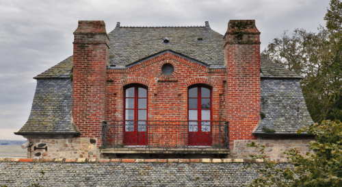 maison pelerin Façade en briques rouges d'une maison ancienne.
